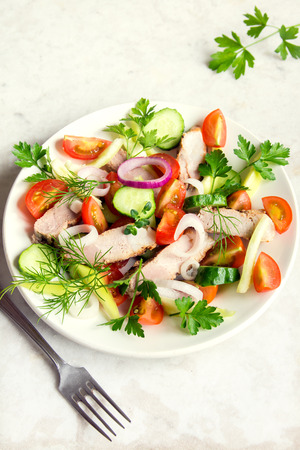 Colorful vegetable salad with meat (roasted pork) on white plate and rustic table top viewの写真素材