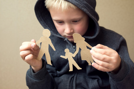 Confused child with broken paper family, family problems, divorce, custody battle, suffer conceptの写真素材