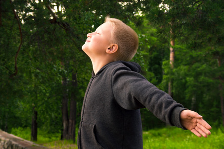 Child practice fitness and pranayama (deep breathing exercises) in the forest (park)の写真素材