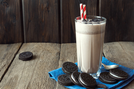 Homemade milkshake (chocolate smoothie) with cookies on rustic wooden table with copy spaceの写真素材