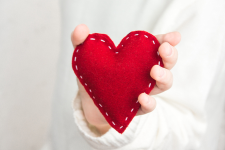 Female hand with red heart over white background, close upの写真素材