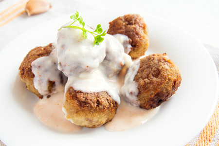 Meatballs with white creamy sauce on plate close upの写真素材