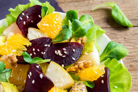 Beetroot and orange salad with greens, pear, nuts and seeds. Healthy vegetarian meal.の写真素材