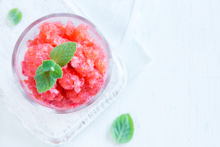 Strawberry granita with mint (frozen dessert) in portion glasses on white background with copy spaceの写真素材
