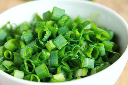 Chopped chives in white bowl, organic green ingredient for cookingの写真素材