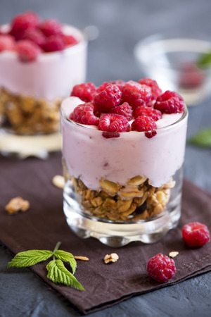 Homemade organic fresh parfait dessert with raspberries and granola, selective focusの写真素材