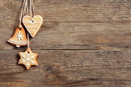 Gingerbread Christmas cookies hanging over wooden background with copy space - festive Christmas pastry and decorの写真素材