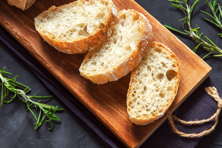 Italian bread Ciabatta and rosemary on black background fresh homemade bread bakeryの写真素材