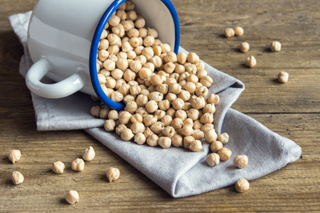 Raw organic chickpeas on rustic wooden background with copy space, healthy vegan vegetarian food ingredientの写真素材