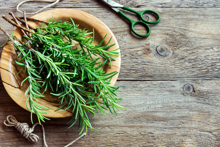 Rosemary leaves bunch close-up. Fresh Organic flavoring plants on wooden table with copy space. Seasonings, cooking, ingredients for healthy food.の写真素材