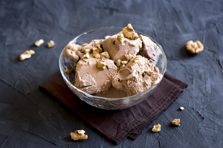 Homemade chocolate ice cream topped with walnuts in glass bowl - healthy homemade dairy free, gluten...