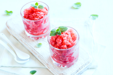 Strawberry granita with mint (frozen dessert) in portion glasses on white background with copy spaceの写真素材