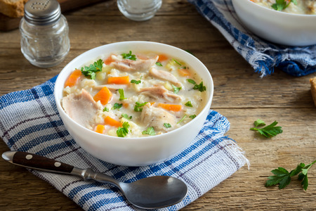 Chicken and Wild Rice Soup. Homemade fresh creamy soup with chicken, vegetables and wild rice in white bowl close up.の写真素材