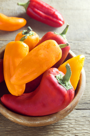 Fresh sweet organic bell peppers on  wooden background  - healthy raw food ingredientの写真素材