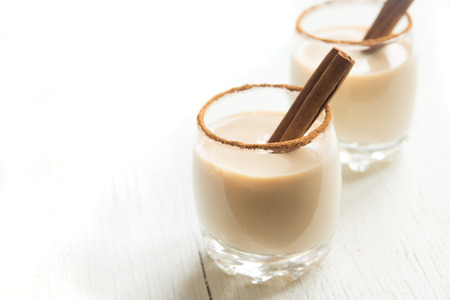 Eggnog with cinnamon and nutmeg for Christmas and winter holidays. Christmas Eggnog, gingerbread cookies isolated on white background.の写真素材