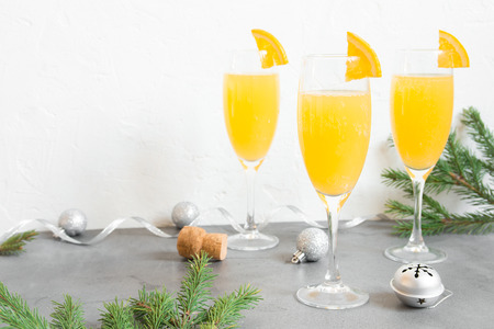 Mimosa festive drink for Christmas - Champagne cocktail Mimosa with Orange juice for Christmas party, copy space