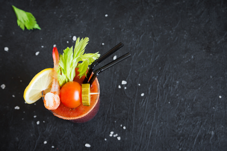 Bloody Mary Cocktail in glass with garnishes. Tomato Bloody Mary spicy drink on black background with copy space.の写真素材