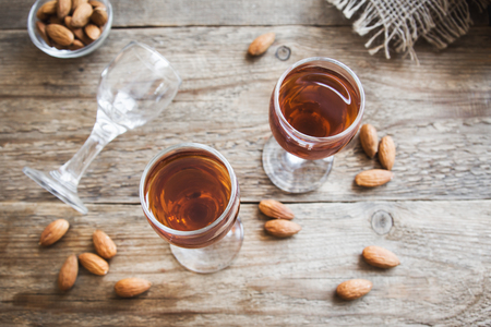 Italian liqueur Amaretto with almonds on rustic wooden background, copy spaceの写真素材