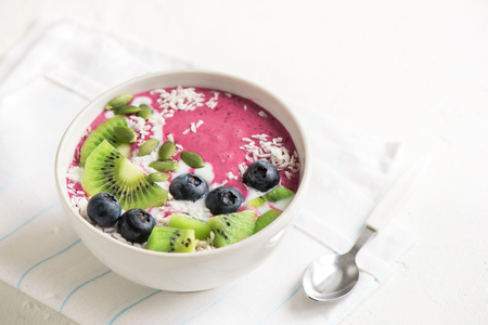 Smoothie bowl with fresh berries, fruits, seeds and coconut cream for healthy vegan vegetarian diet breakfast. Acai blueberry coconut smoothie bowl.の写真素材