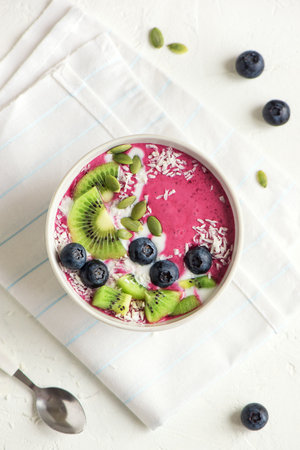 Smoothie bowl with fresh berries, fruits, seeds and coconut cream for healthy vegan vegetarian diet breakfast. Acai blueberry coconut smoothie bowl.の写真素材