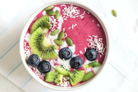 Smoothie bowl with fresh berries, fruits, seeds and coconut cream for healthy vegan vegetarian diet breakfast. Acai blueberry coconut smoothie bowl.の写真素材