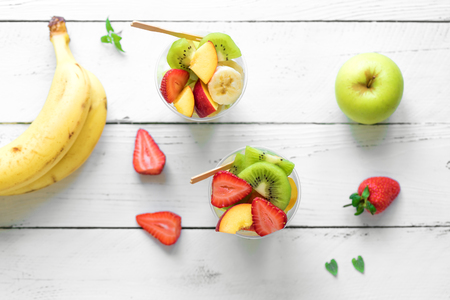 Fruit salad in plastic cups takeaway. Sliced organic fruits and berries, healthy snack to go, copy space.の写真素材