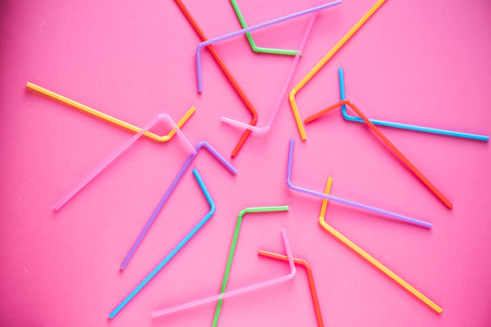 Drinking straws on pink background. Summer cocktail party, fun and happy vacation concept.の写真素材