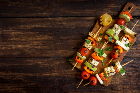 Vegetarian grilling. Vegetarian skewers with halloumi cheese and vegetables on rustic wooden background, copy space.の写真素材