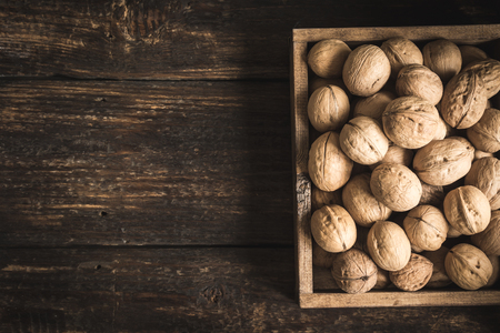 Organic Walnuts in rustic wooden box, top view. Seasonal harvest of walnuts.の写真素材