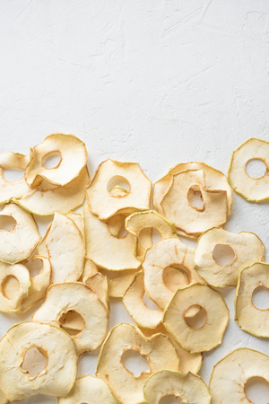 Apple dehydrated fruit chips on white background, copy space, healthy vegan snack.の写真素材