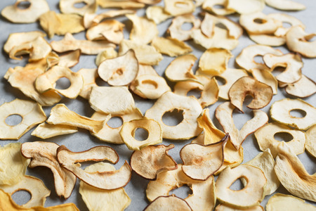 Various fruit chips as background, copy space. Assorted dehydrated apple, pear, melon, mango fruit chips - healthy vegan snack.の写真素材