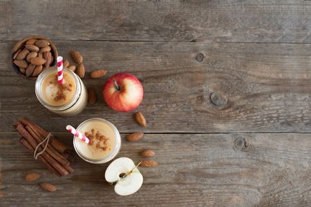 Apple pie protein smoothie drink with almond milk. Homemade apple smoothie with apple pie spices (cinnamon) on wooden background, copy space.の写真素材