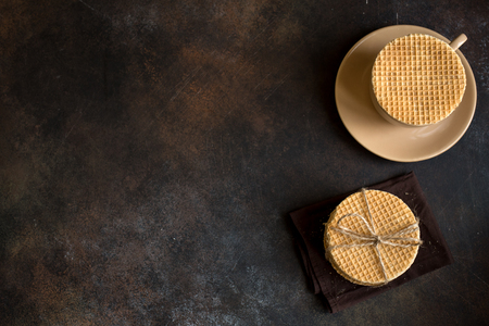 Dutch waffles, stroopwafel with caramel and hot drink. Traditional homemade dutch waffles on dark rustic table.の写真素材