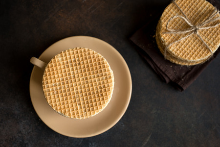 Dutch waffles, stroopwafel with caramel and hot drink. Traditional homemade dutch waffles on dark rustic table.の写真素材