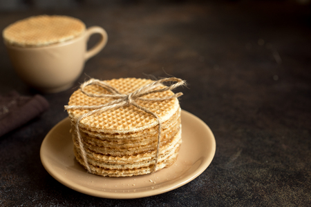 Dutch waffles, stroopwafel with caramel and hot drink. Traditional homemade dutch waffles on dark rustic table.の写真素材