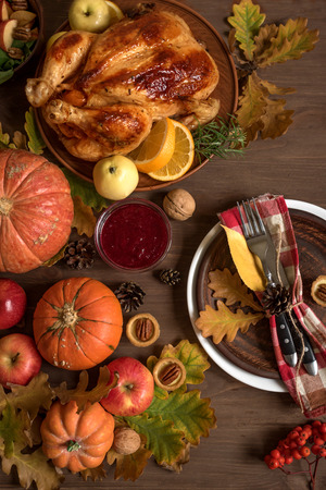 Thanksgiving Dinner background with Turkey, fall leaves, seasonal autumnal fruits, decor and table setting, top view.の写真素材