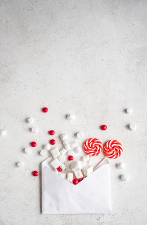 Christmas composition with sweets and envelop, flat lay on white, copy space. Christmas greeting card with candies.の写真素材