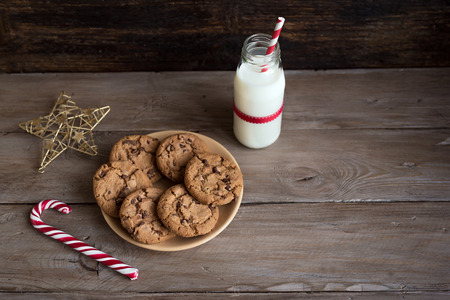 Cookies and Milk for Santa. Traditional Christmas homemade chocolate chip cookies, candy cane and...