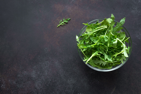 Fresh Arugula Salad on dark background, copy space. Organic Arugula Leaves - healthy food salad ingredient.の写真素材