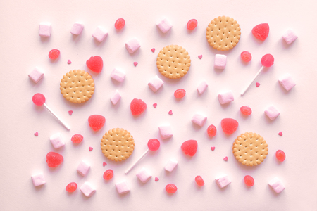 Pink candies, marshmallows and cookies pattern, background. Various pink sweets for Valentine Day as backdrop, top view.の写真素材