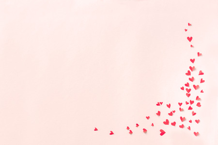 Red hearts on pink pastel background. Romantic love concept, Valentine day or wedding theme, copy space.の写真素材