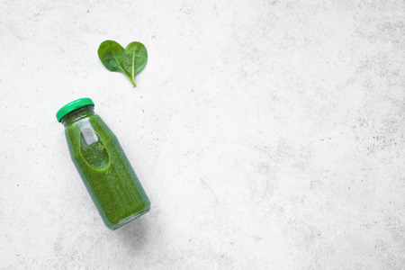 Green Smoothie Bottle  with heart shaped spinach on white background, top view. Detox, clean eating, diet and healthy eating concept, copy space.の写真素材