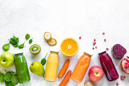 Various smoothies or juices in bottles and ingredients on white, healthy diet detox vegan clean food concept, top view, copy space.の写真素材