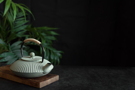 Iron Teapot on black background, copy space. Traditional Asian arrangement  for Tea ceremony -  iron teapot  with tea.の写真素材