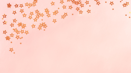 Pink background with stars, copy space. Golden stars confetti on pastel coral background, mockup.の写真素材
