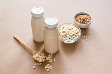 Oat Milk alternative on beige background, copy space. Healthy vegan substitute dairy free drink - bottle of oat milk.の写真素材