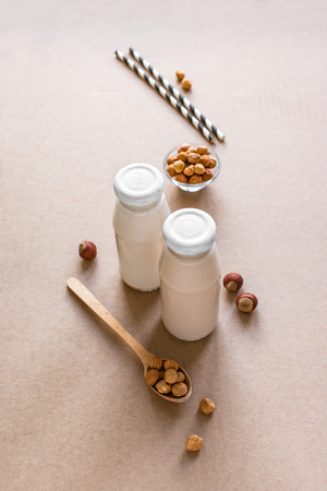 Hazelnut Milk  on beige background, copy space. Healthy vegan alternative substitute dairy free drink - bottle of hazelnut milk.の写真素材