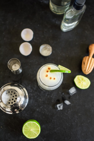 Pisco Sour Cocktail. Peruvian, Mexican, Chilean traditional drink pisco sour liqueur with  lime and egg and bar equipment for making.の写真素材