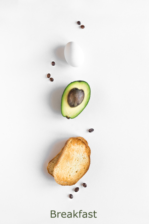 Avocado, egg and toast for breakfast on white background, top view, copy space. Healthy breakfast ingredients - egg, bread, avocado and coffee beans.の写真素材