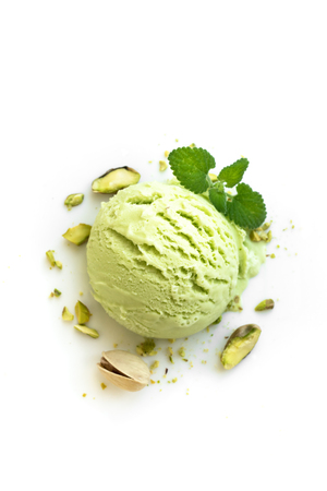 Pistachio Ice Cream isolated on white background, top view. Green pistachio gelato with pistachio nuts and mint.の写真素材